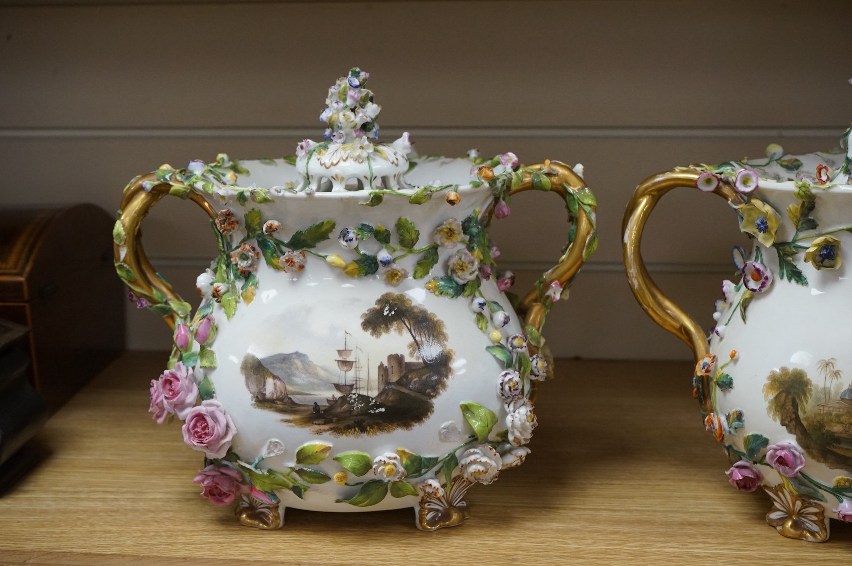 A pair of Rockingham two handled pot pourri vases and covers, c.1830-42, the first painted with two named views near Lyme, Dorsetshire and Stockly Bridge’, The second with an unnamed view of a monument by a lake, the rev